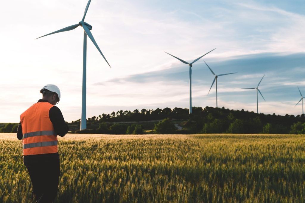 Travailleur debout sous une éolienne