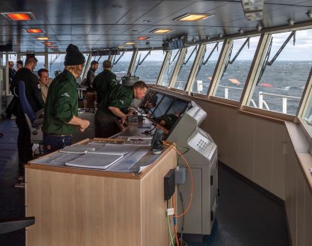 Travailleurs à l’intérieur d’un navire devant un système de navigation
